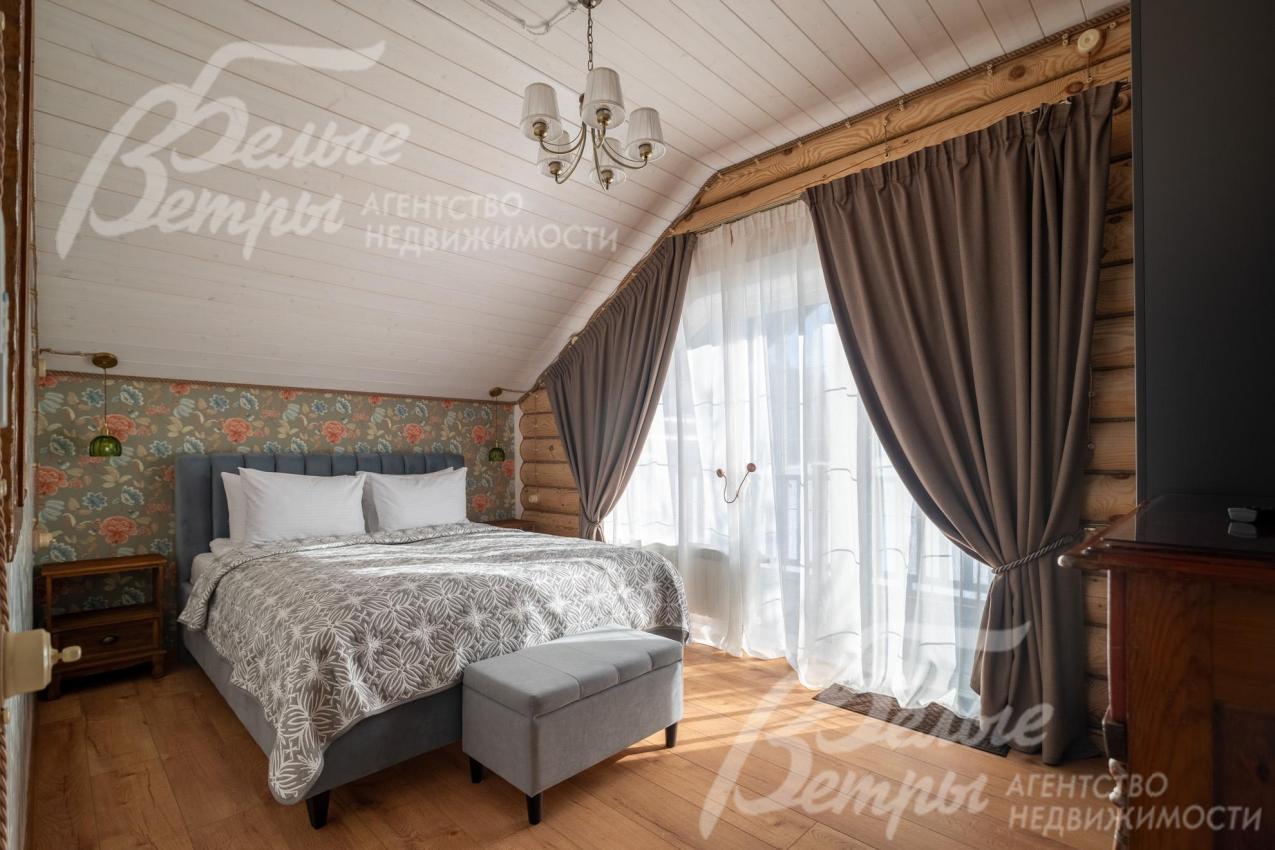 Одна из спален на втором этаже: на стенах - обои, пол выполнен из качественного ламината