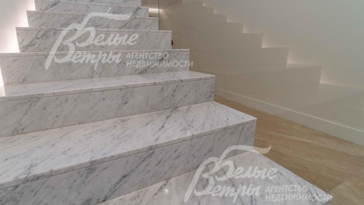 Ступени лестницы отделаны напиленным (рисунок продолжается от ступени к ступени) мрамором из слэба Bianco Carrara (Италия)