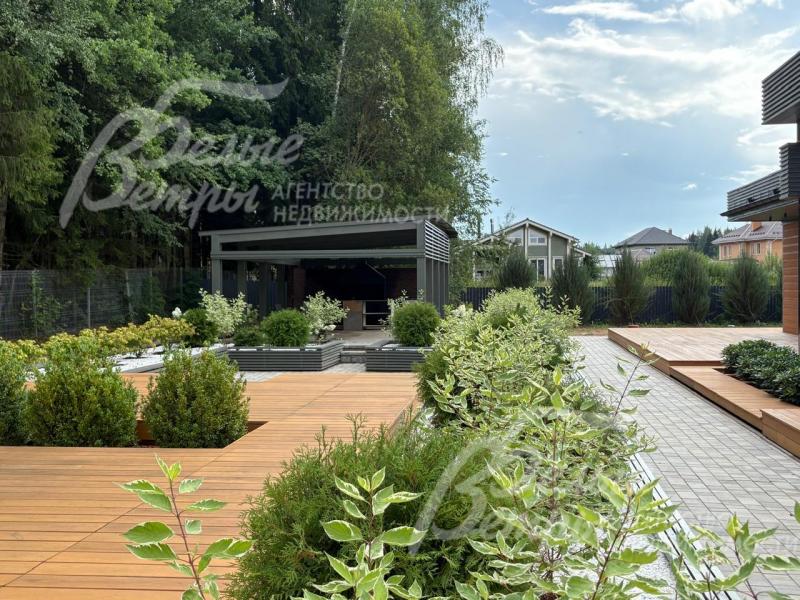 Дом стоит на участке со стильным ландшафтным дизайном