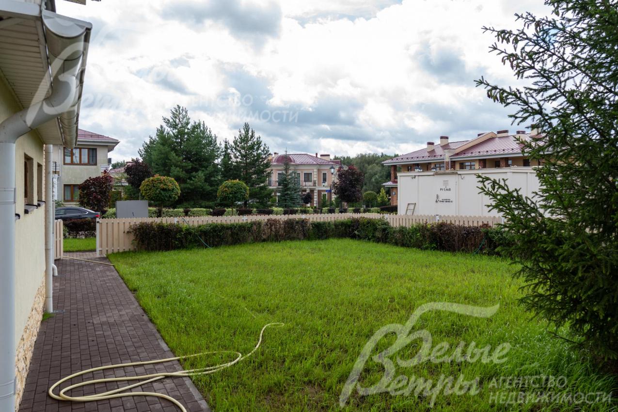 Участок огорожен невысоким забором и живой изгородью