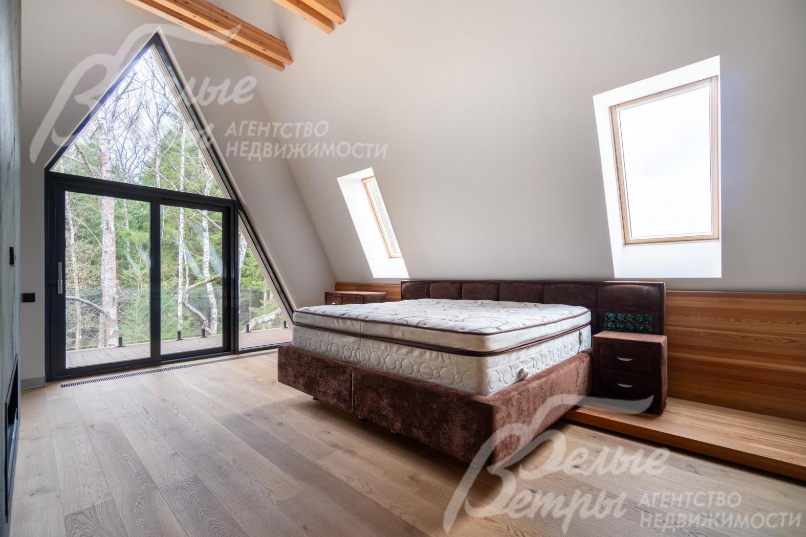 Мастер-спальня на втором этаже дома - с выходом на балкон и тремя мансардными окнами