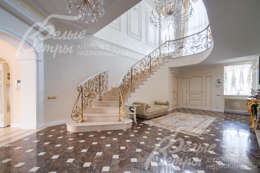  На второй этаж ведёт элегантная изогнутая железобетонная лестница: ступени — мраморные, ограждение — изящная художественная ковка с золотой патиной, дополненная деревянными поручнями, плавно повторяющими изгиб лестничного марша