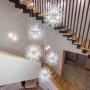 По центру над лестницей располагается эффектная подвесная люстра в стиле «одуванчик»