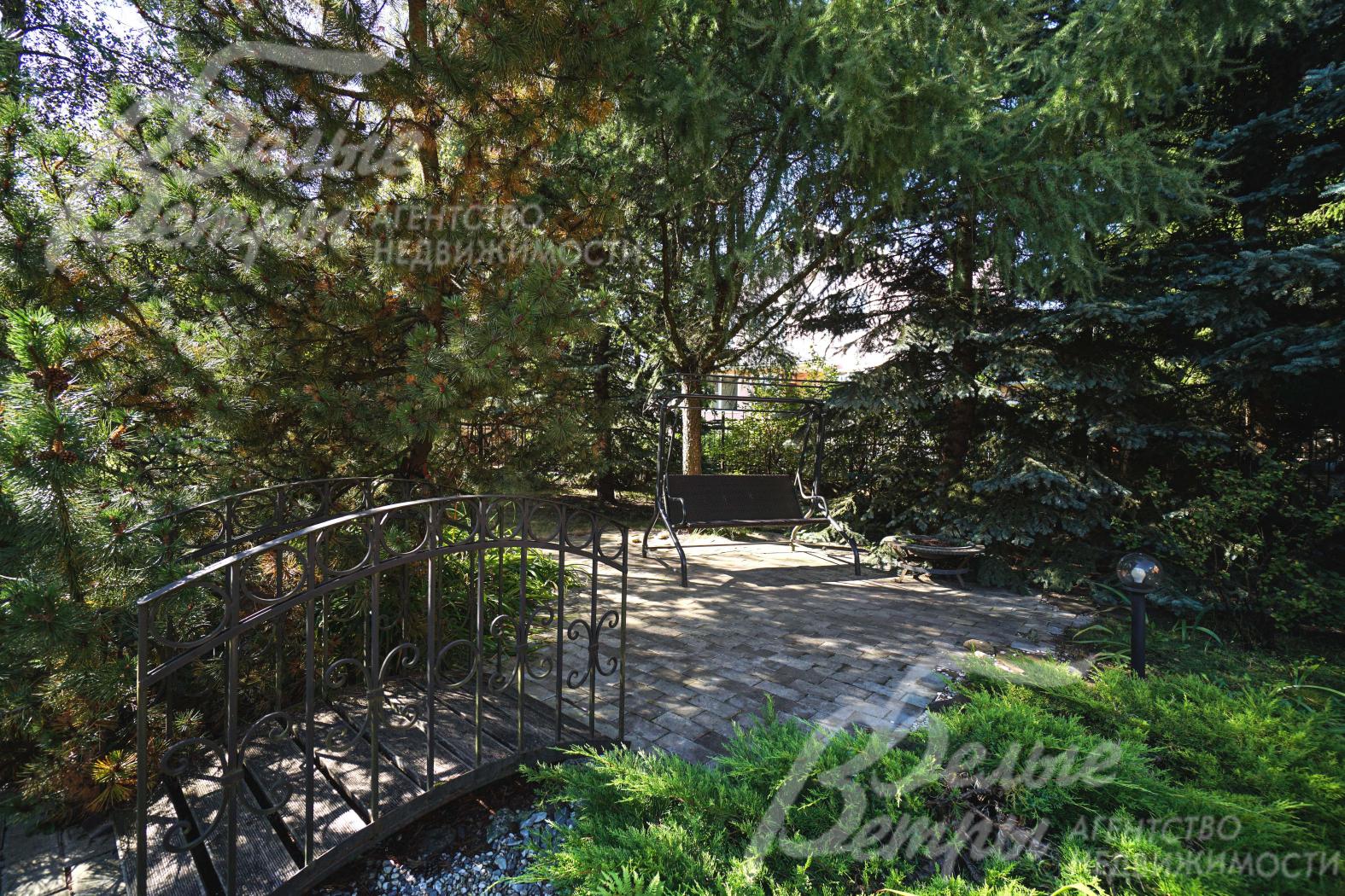 Участок украшает сухой ручей с мостиком, есть мощёная площадка для отдыха с качелями