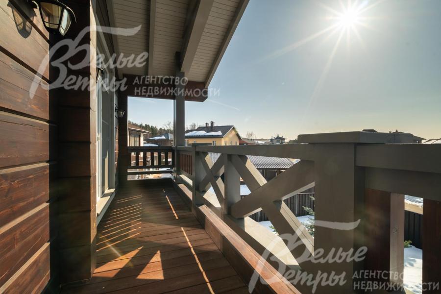 Из каждой спальни на втором этаже - выход на крытый балкон с видом на коттеджный посёлок и лес