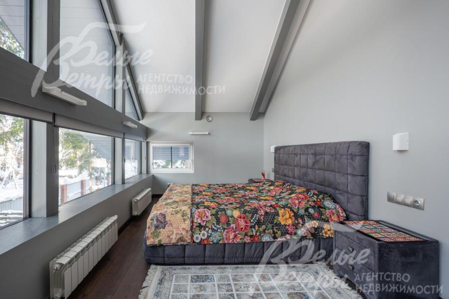 Спальня мастер-блока на втором этаже с панорамным остеклением и высокими потолками