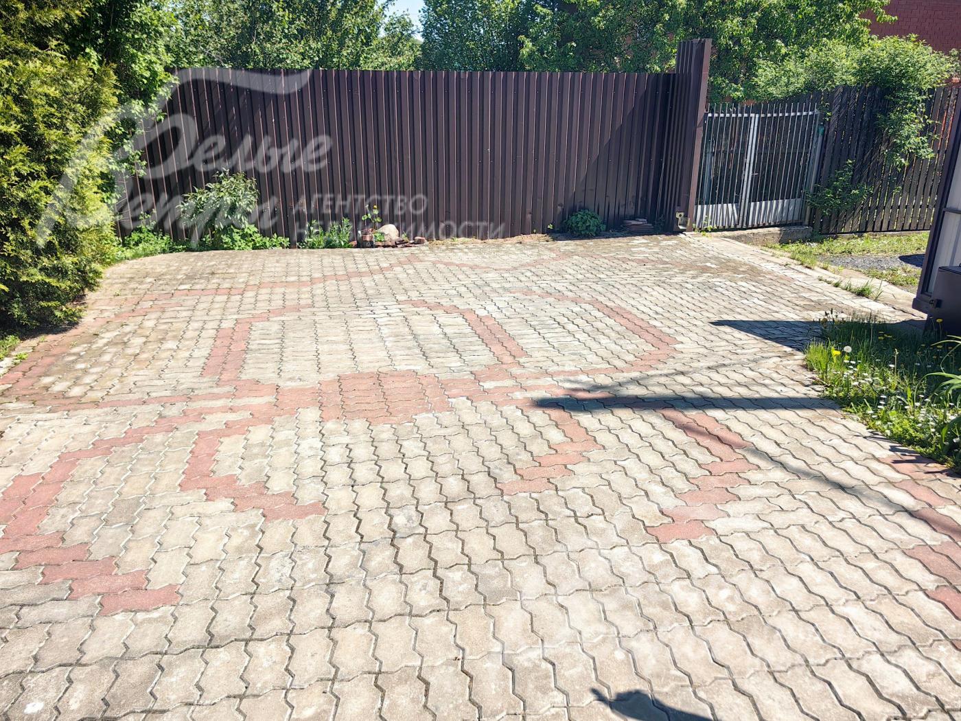 Мощеная парковка перед гаражом.