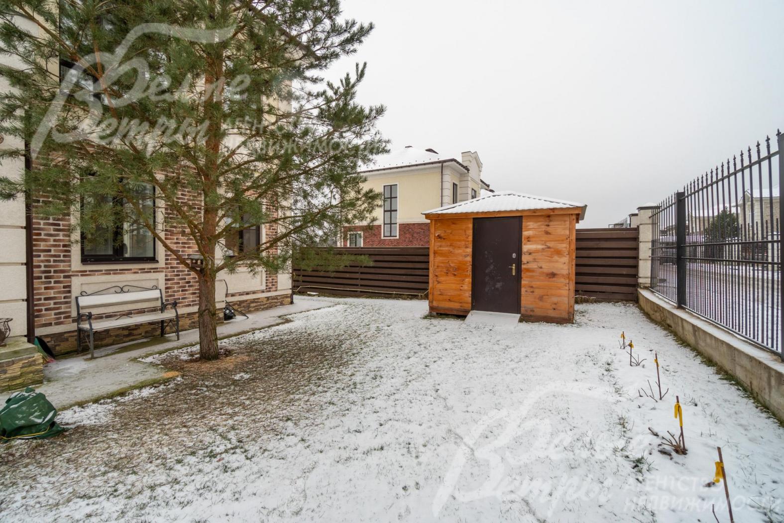 На участке высажен газон, дорожки выполнены из бетона без дополнительной облицовки, есть скамейка у сосны