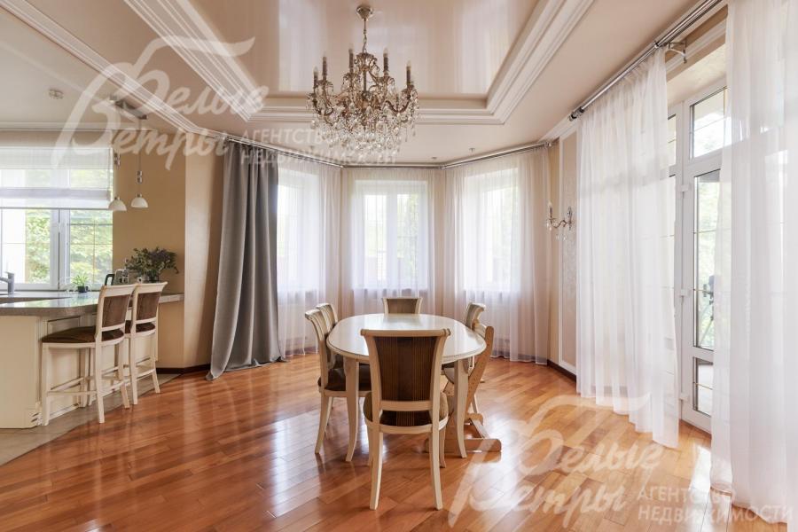 В гостиной много света благодаря большим окнам и остеклённому эркеру. Справа - выход на остеклённую террасу