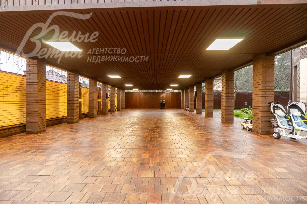 Парковка под навесом для 6 автомобилей - на кирпичных столбах, построена в едином архитектурном стиле, есть зарядные станции для электромобилей