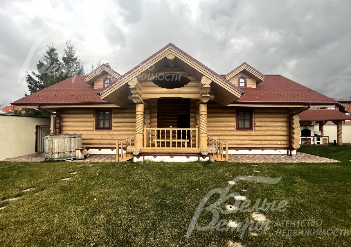 На участке построена баня с гостевой спальней и террасой, у бани стоит чан (бочка)