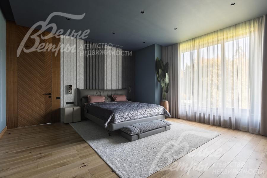 Одна из спален на втором этаже. На полу - инженерная доска. Межкомнатные двери высотой 2,75м выполнены из шпона американского ореха