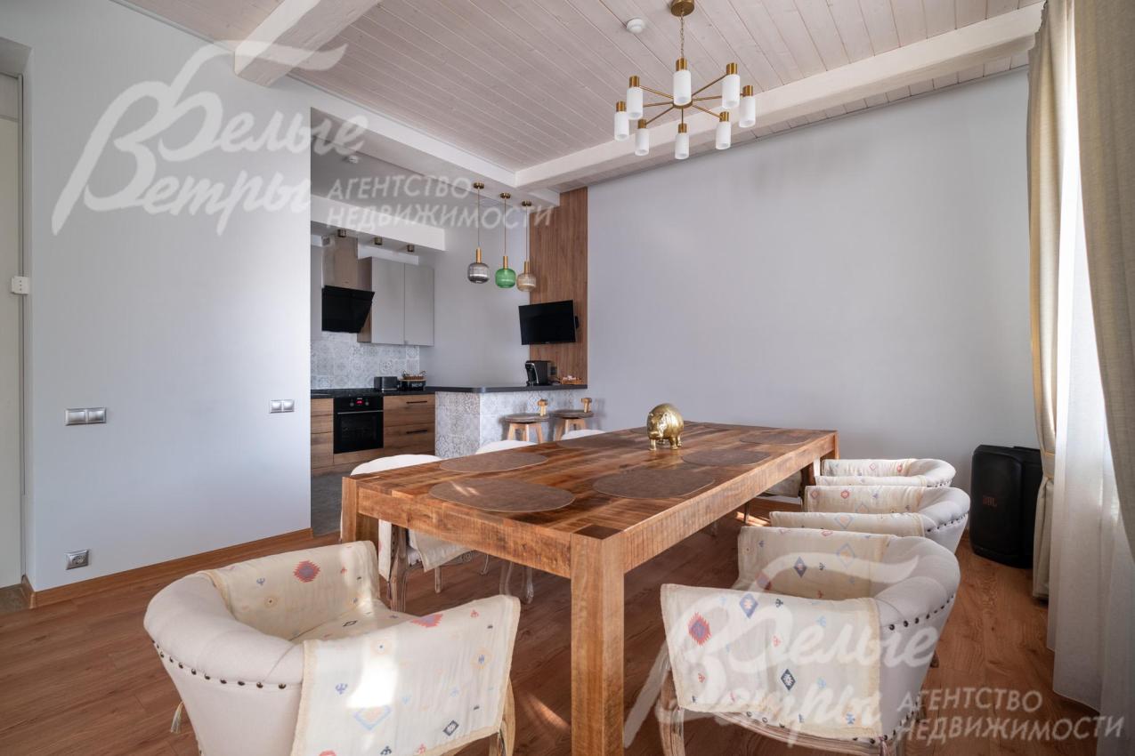 В столовой установлен большой эффектный обеденный стол на 10 персон из дерева манго