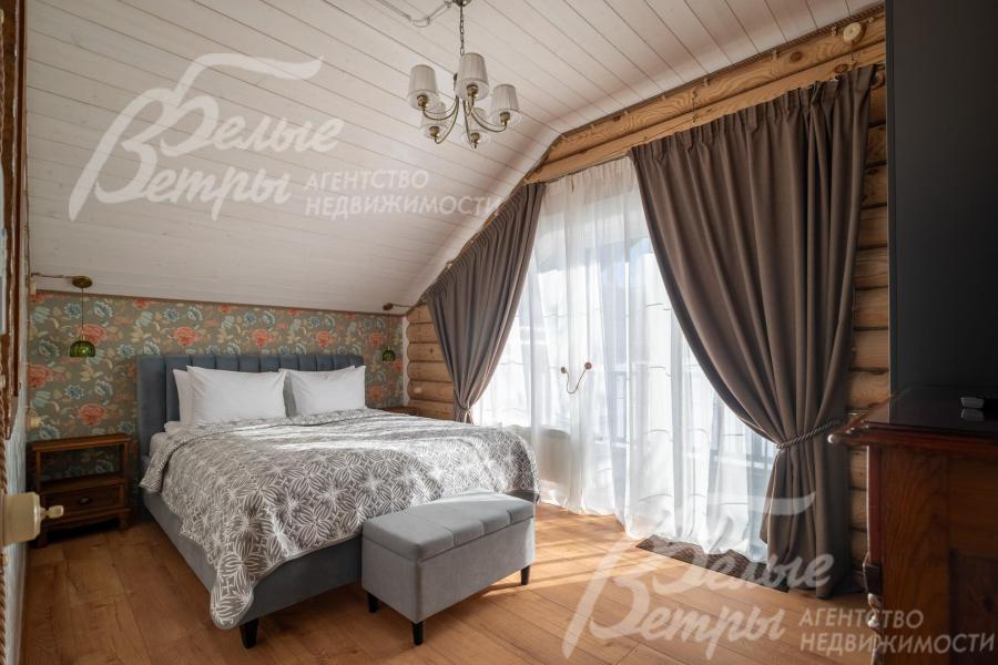 Одна из спален на втором этаже: на стенах - обои, пол выполнен из качественного ламината