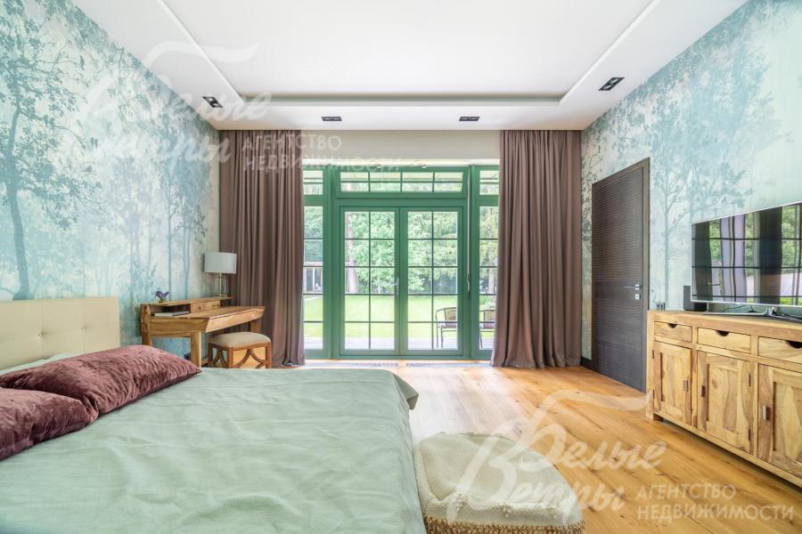 Мастер-спальня на первом этаже с окном в пол и выходом на террасу