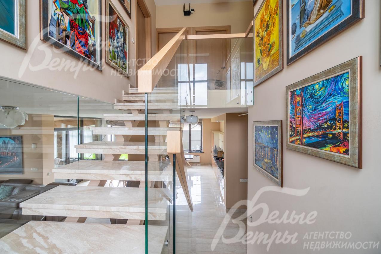 Парящая лестница с дубовыми поручнями и ступенями, облицованными мрамором