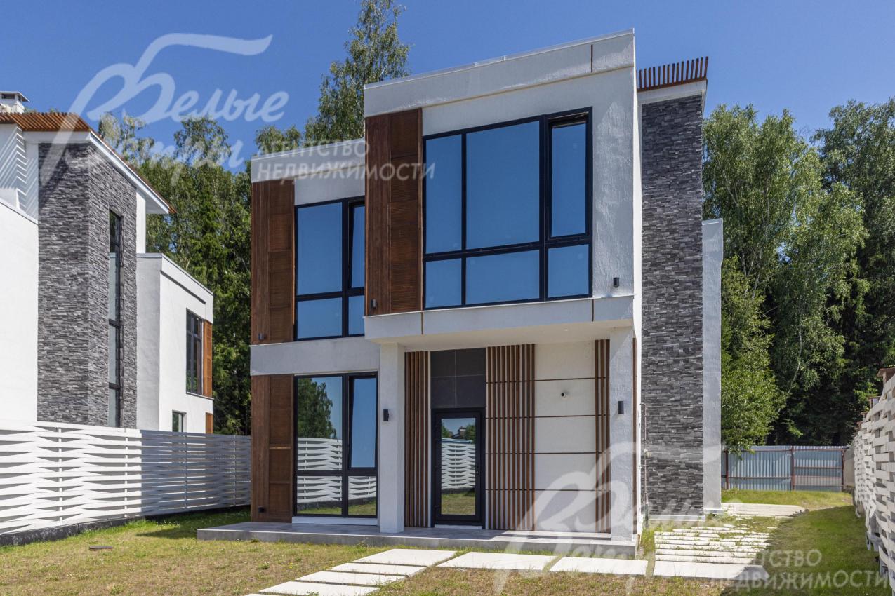 Эффектный экстерьер дома сочетает в себе выразительные формы, контрастную отделку стен и масштабные ламинированные панорамные окна