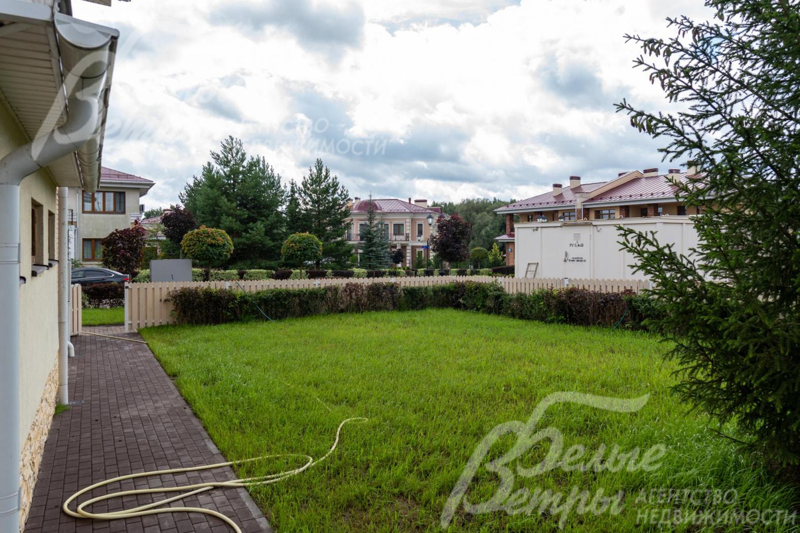 Участок огорожен невысоким забором и живой изгородью