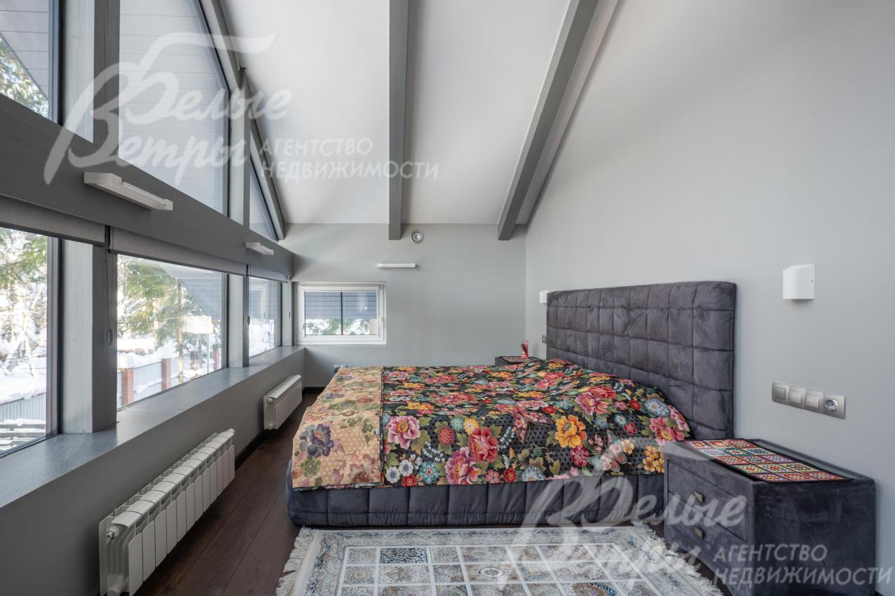 Спальня мастер-блока на втором этаже с панорамным остеклением и высокими потолками