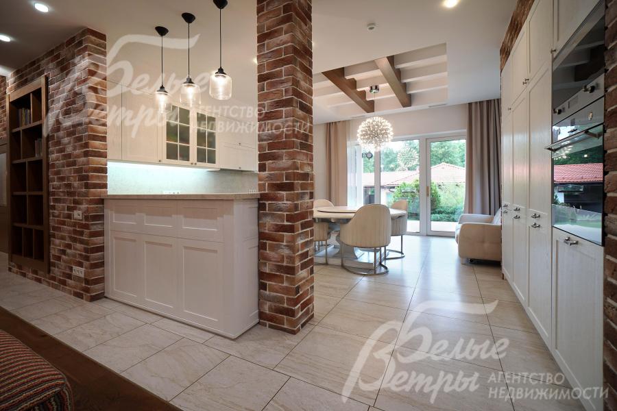 Пространство у входа на кухню зонировано барной стойкой и декоративной колонной