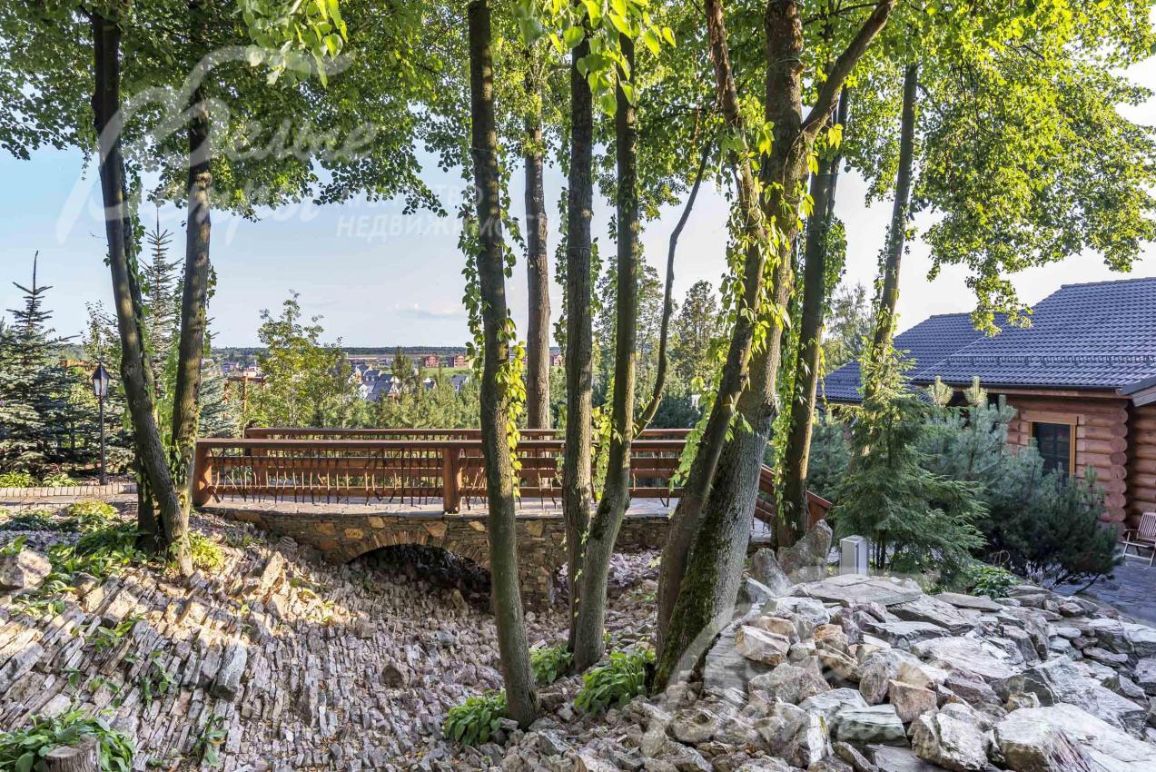 Мостик рядом с водным каскадом с каменистым гребнем