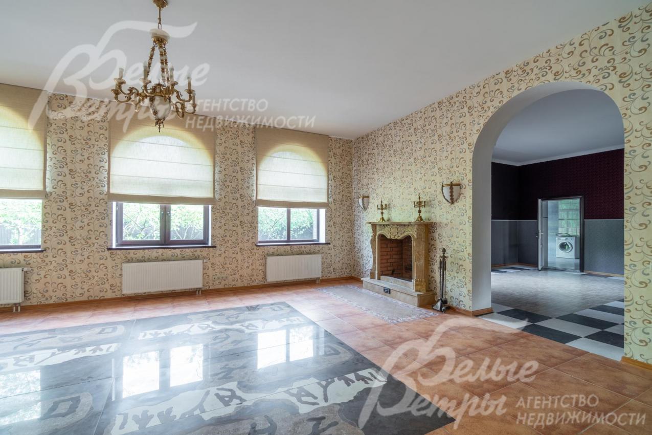 Гостиная с эркерными окнами и классической входной аркой