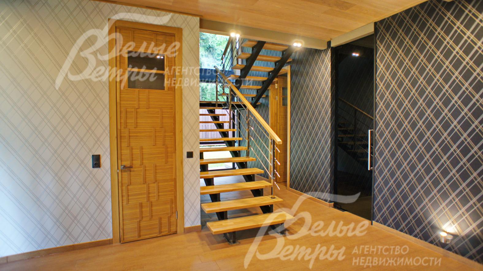 Отделка выполнена из натуральных материалов: лиственница, камень, бумажные обои. Высокие дверные проемы