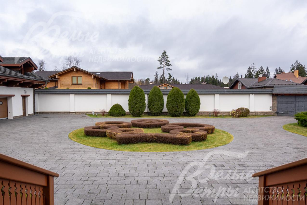 Перед главным входом - круглая клумба с кустами спиреи сложной конфигурации, парковка у дома рассчитана на более, чем 10 автомобилей