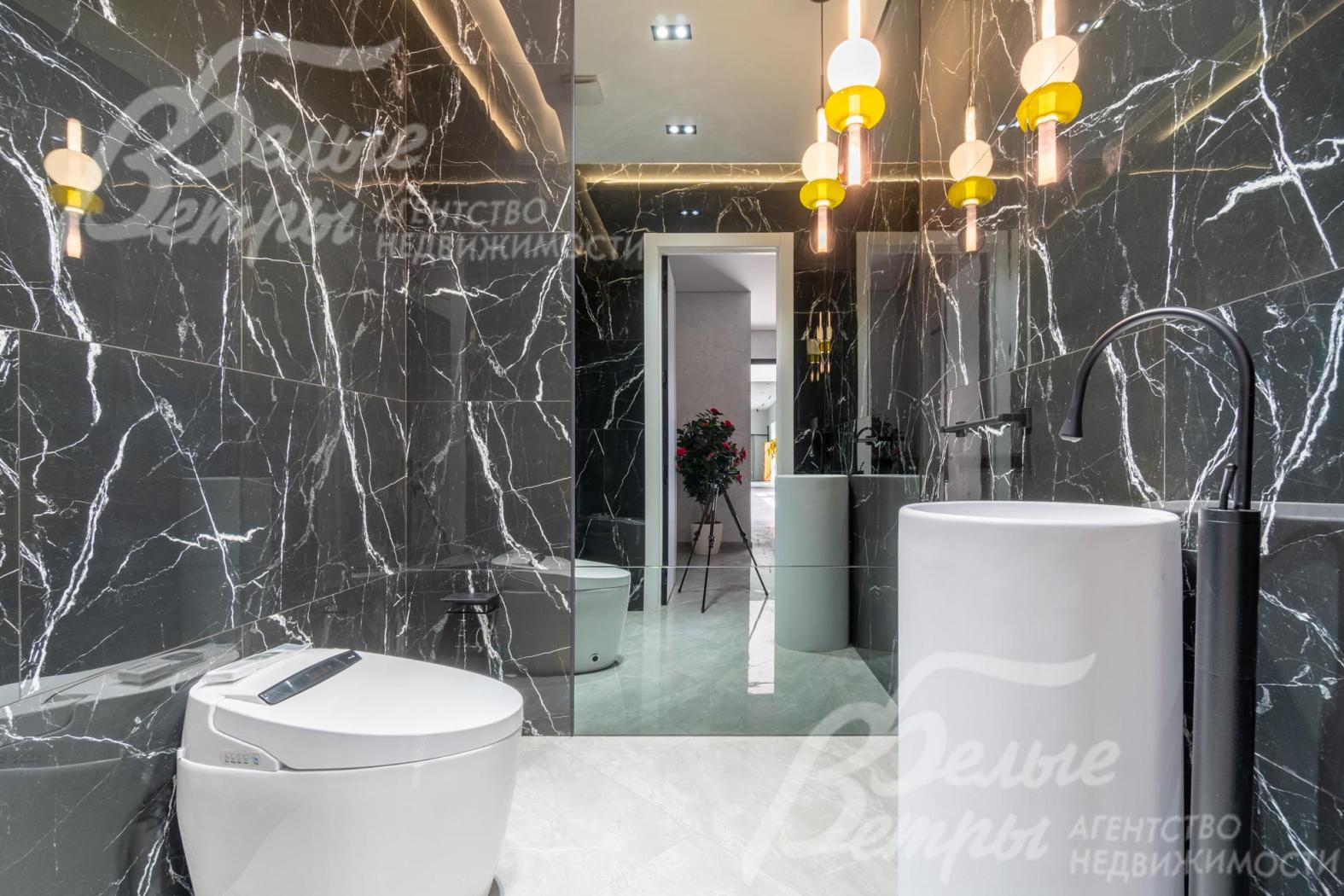 Санузел на втором этаже с зеркалом в пол, отделан плиткой под чёрный мрамор 