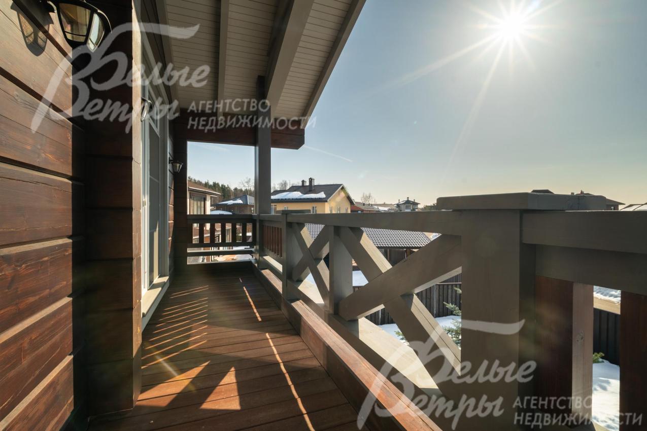 Из каждой спальни на втором этаже - выход на крытый балкон с видом на коттеджный посёлок и лес