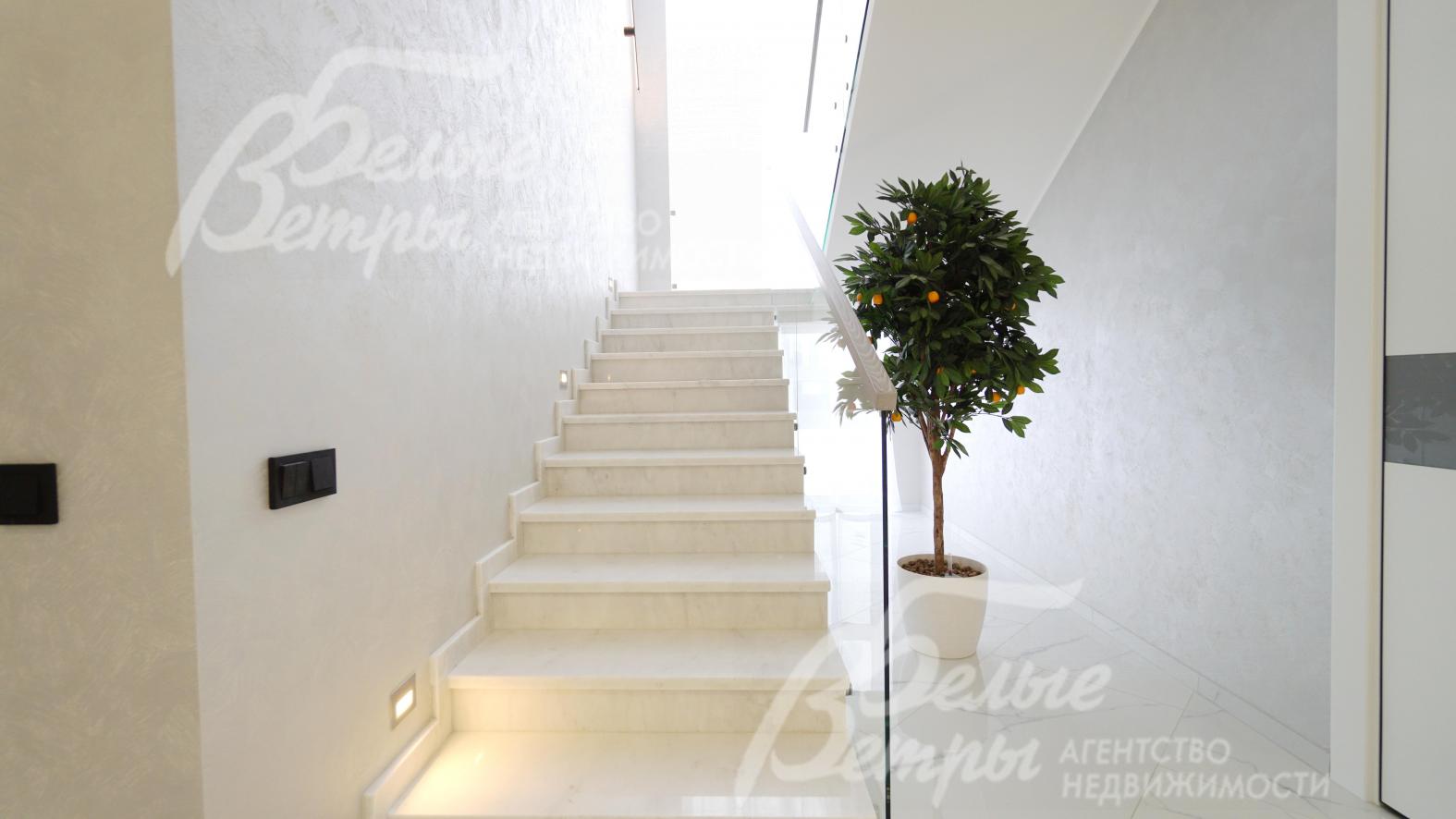 Железобетонная лестница с отделкой ступеней мрамором, стеклянным ограждением и дубовым поручнем