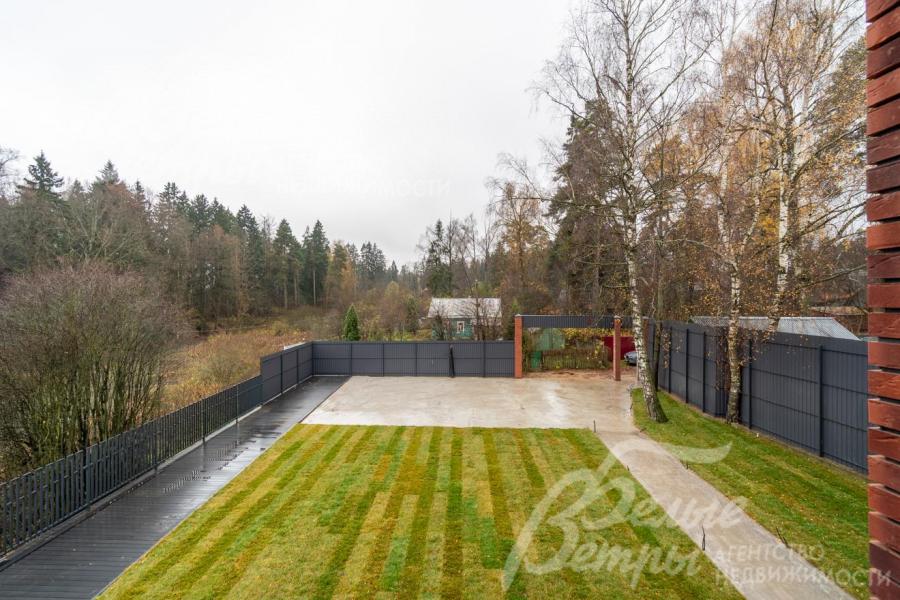 С одного из балконов открывается вид на въездную зону, парковку и окружающий природный ландшафт