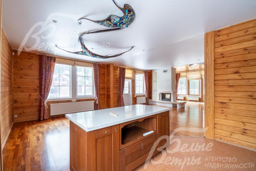 В просторном пространстве кухни-столовой и гостиной пол зонирован с помощью комбинирования разных напольных покрытий в единой цветовой гамме