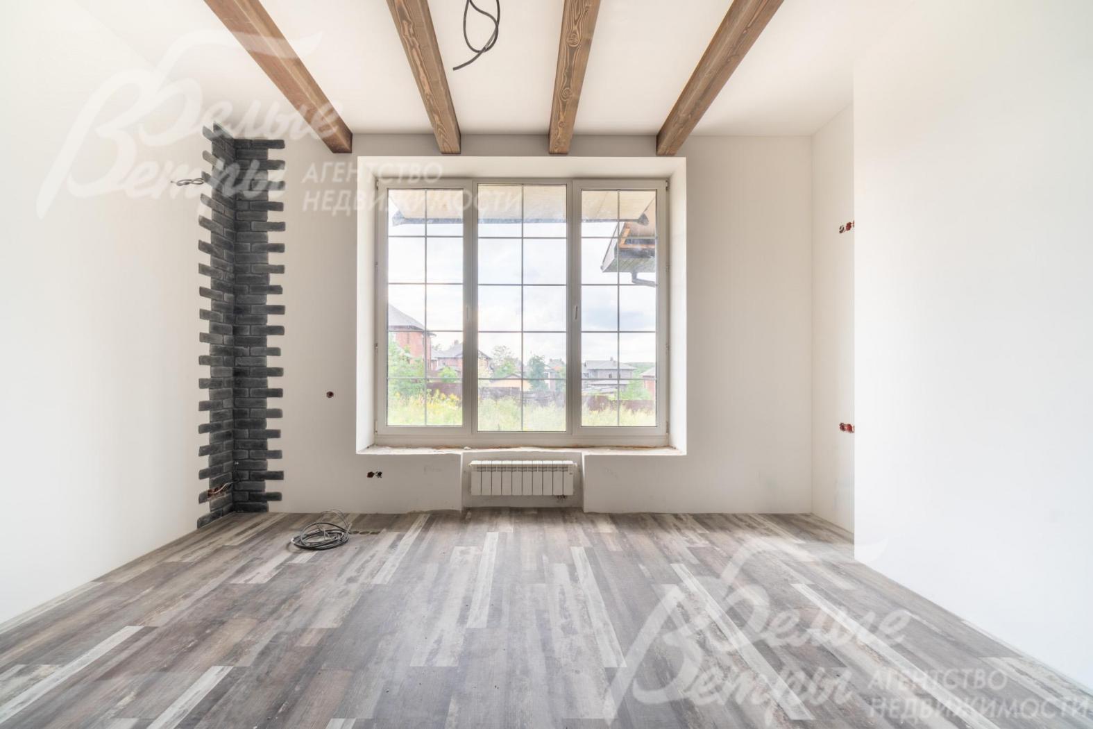 Одна из жилых комнат на втором этаже: угловая часть стены декорирована выразительной контрастной отделкой "под кирпич"