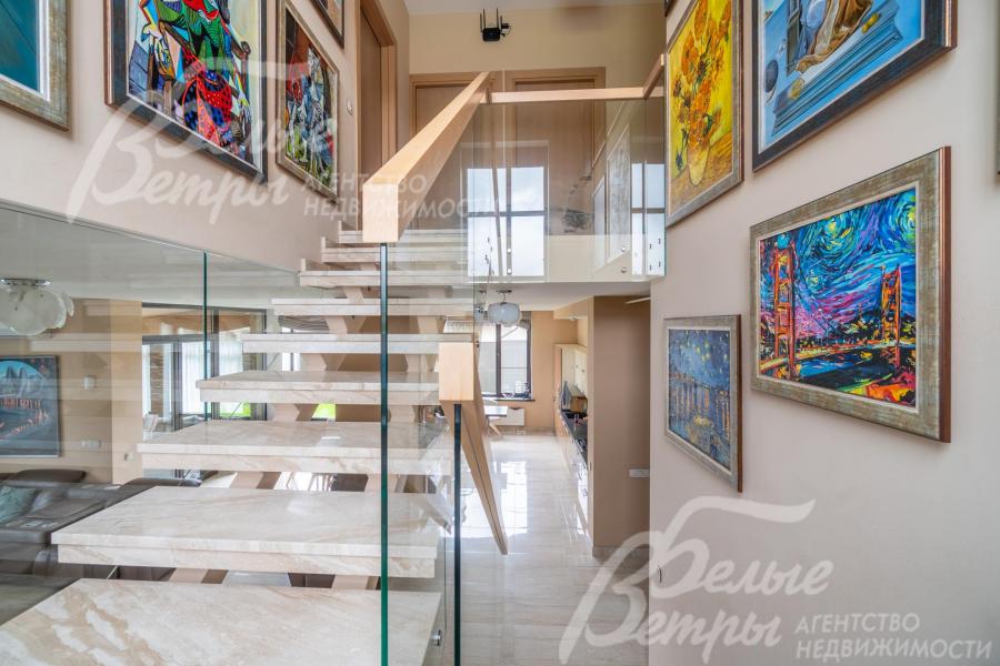 Парящая лестница с дубовыми поручнями и ступенями, облицованными мрамором