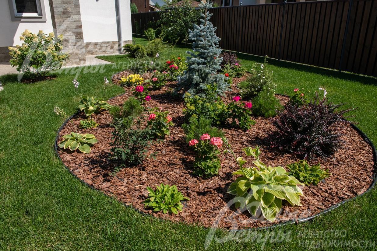 Ландшафтный дизайн дополняют эффектные клумбы, на участке высажен идеальный газон