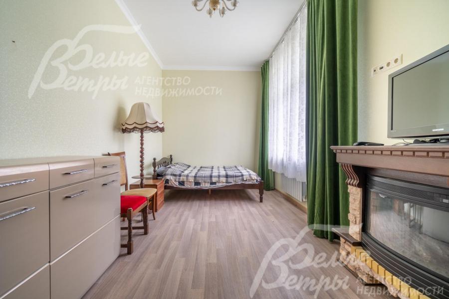 Спальня на первом этаже с большим окном и мебелью