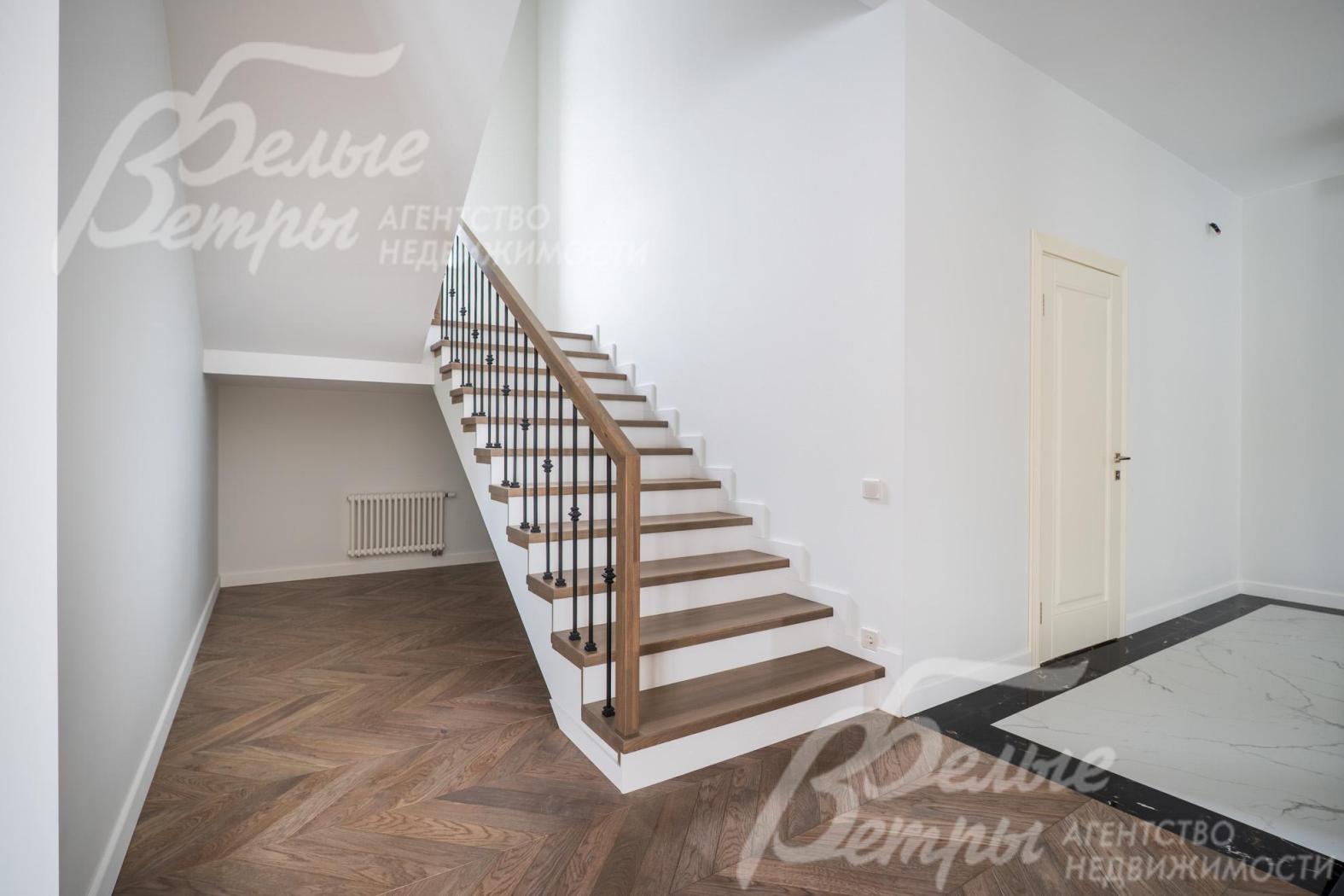 Удобная лестница на монолитном каркасе со ступенями из дуба.