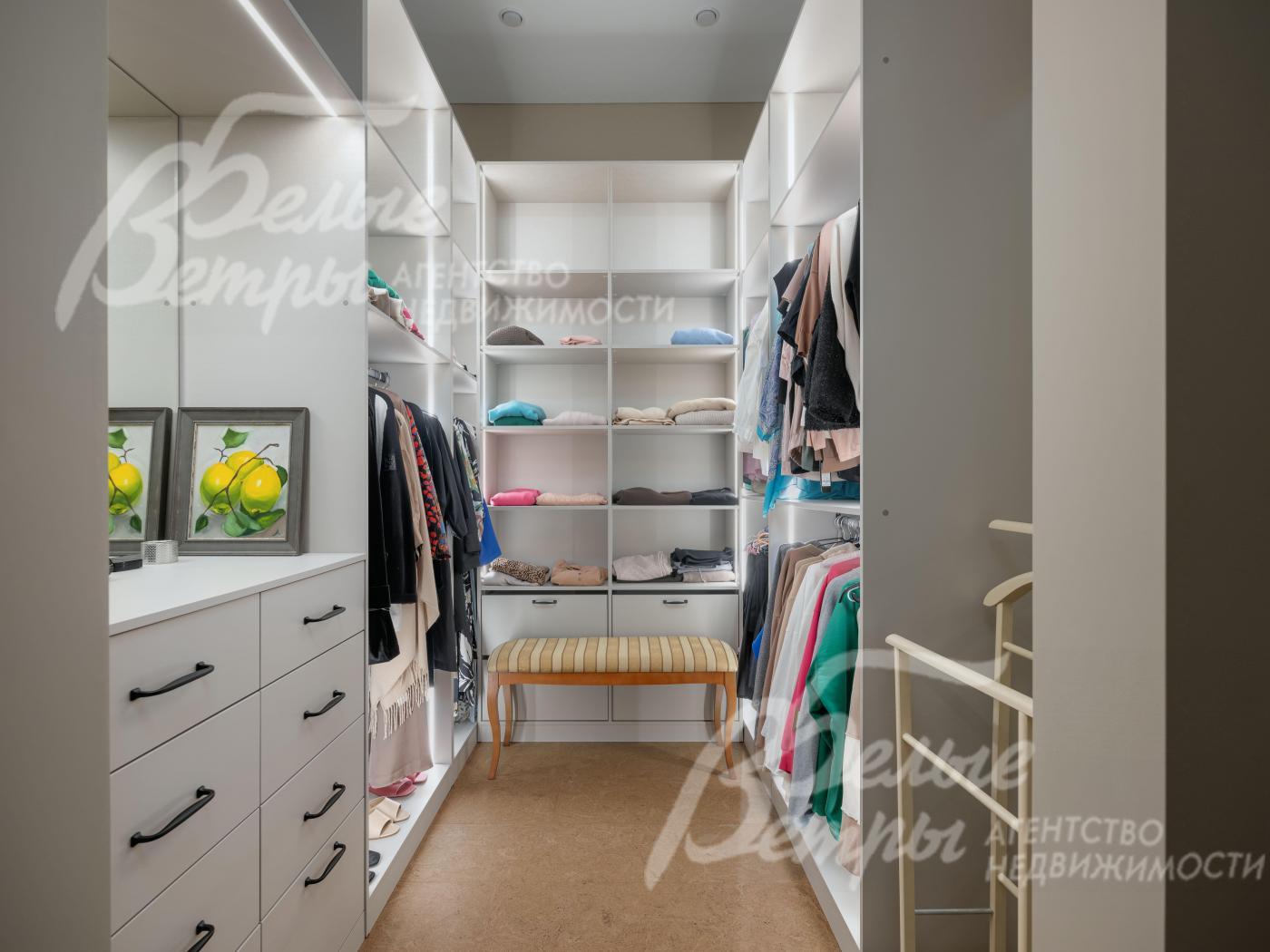 Гардеробная мастер-спальни с системой хранения, удобным пуфом и комодом