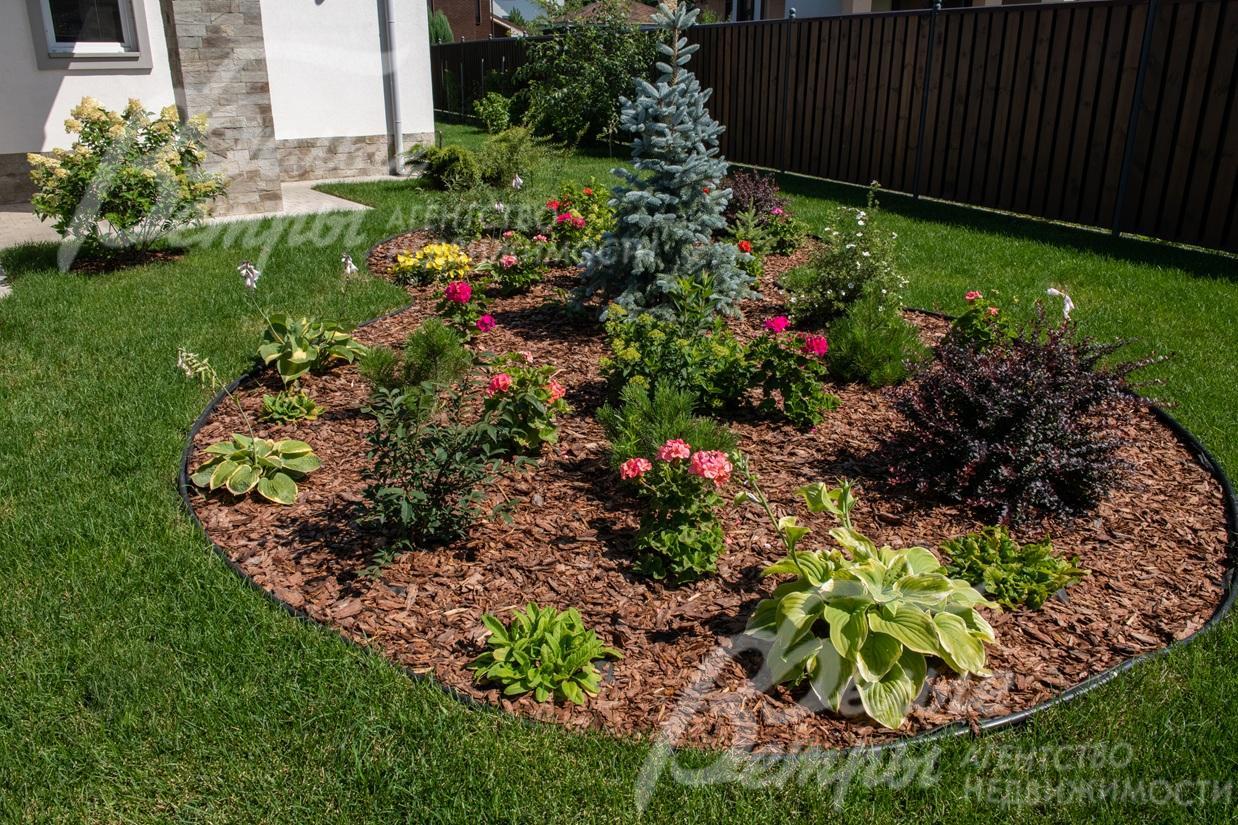 Ландшафтный дизайн дополняют эффектные клумбы, на участке высажен идеальный газон