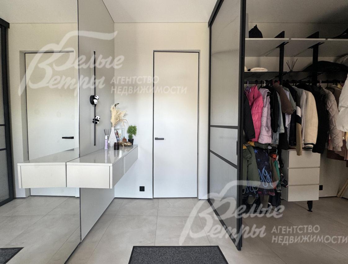 Прихожая дома: справа - просторная гардеробная, слева - зеркало во всю стену