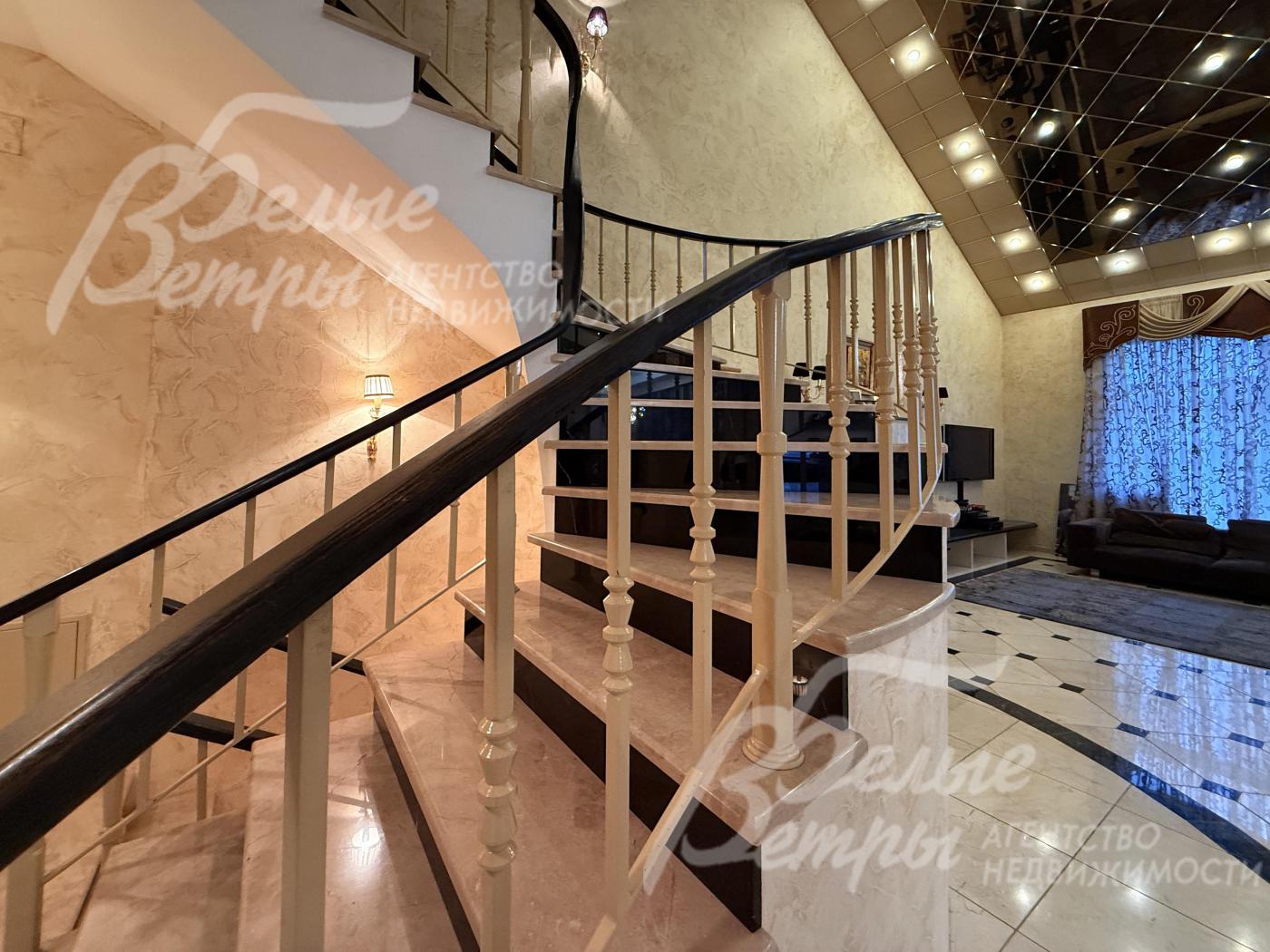 Рядом с гостиной - каминный зал со вторым светом и винтовой лестницей на второй этаж