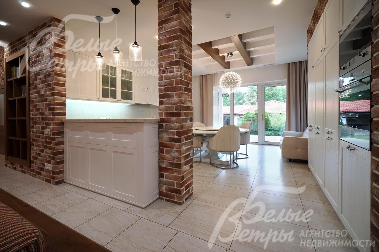 Пространство у входа на кухню зонировано барной стойкой и декоративной колонной