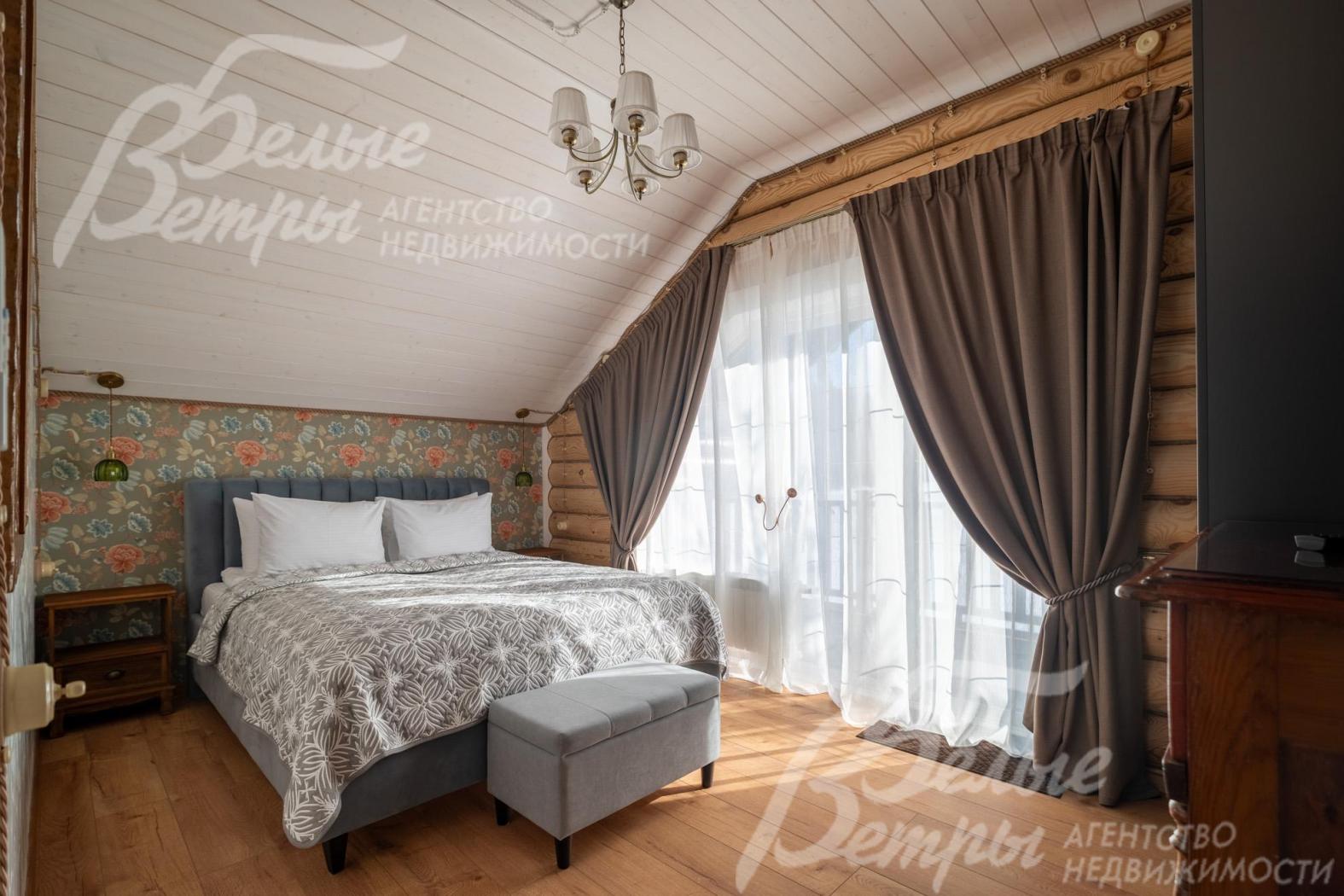 Одна из спален на втором этаже: на стенах - обои, пол выполнен из качественного ламината