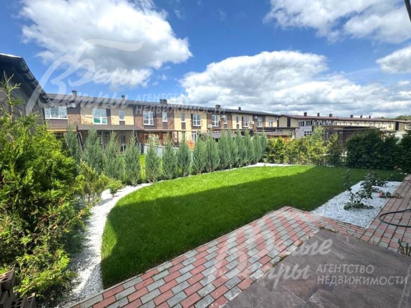 Участок засеян газоном, высажены кустарники и деревья