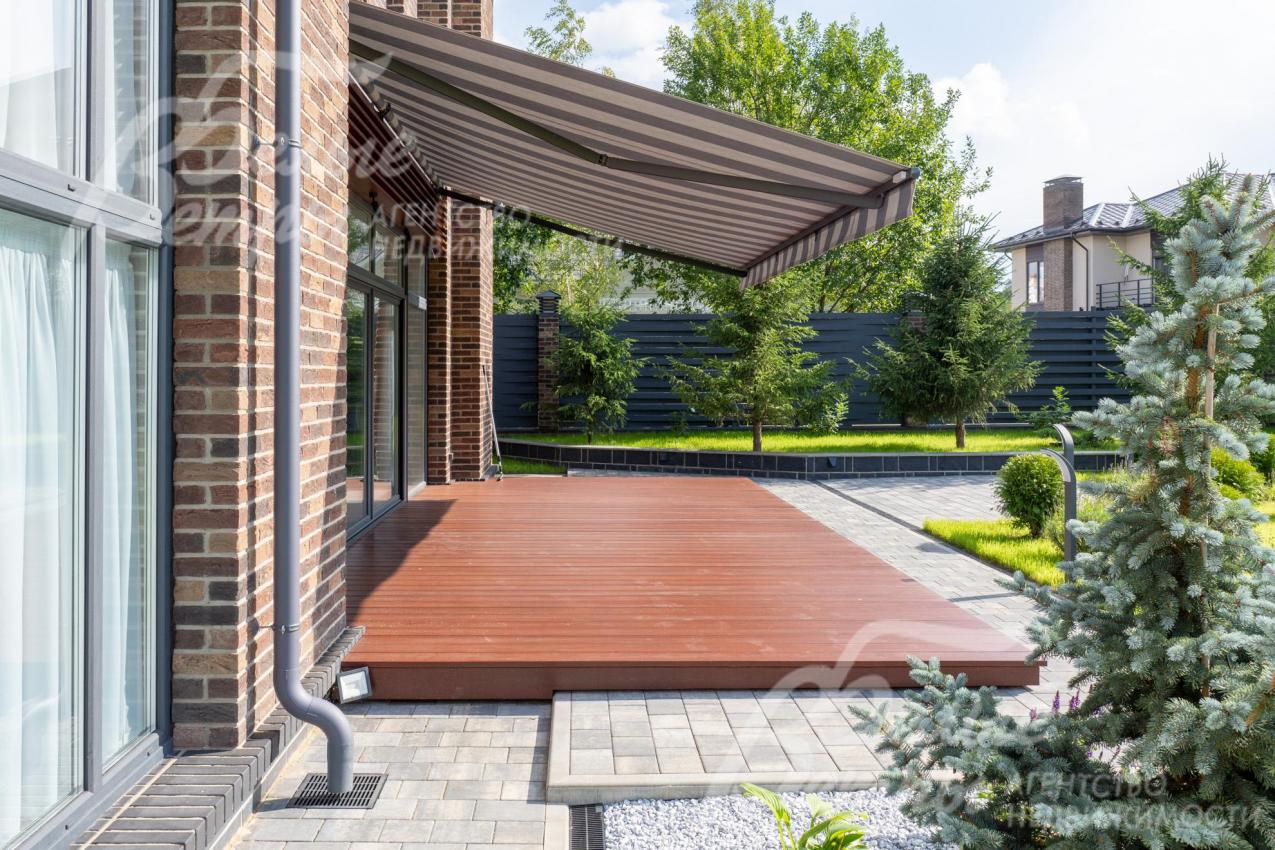 Вокруг террасы – шаровидные туи, кусты лаванды и шалфея. Дорожки на участке выложены плиткой, выполнено уличное освещение