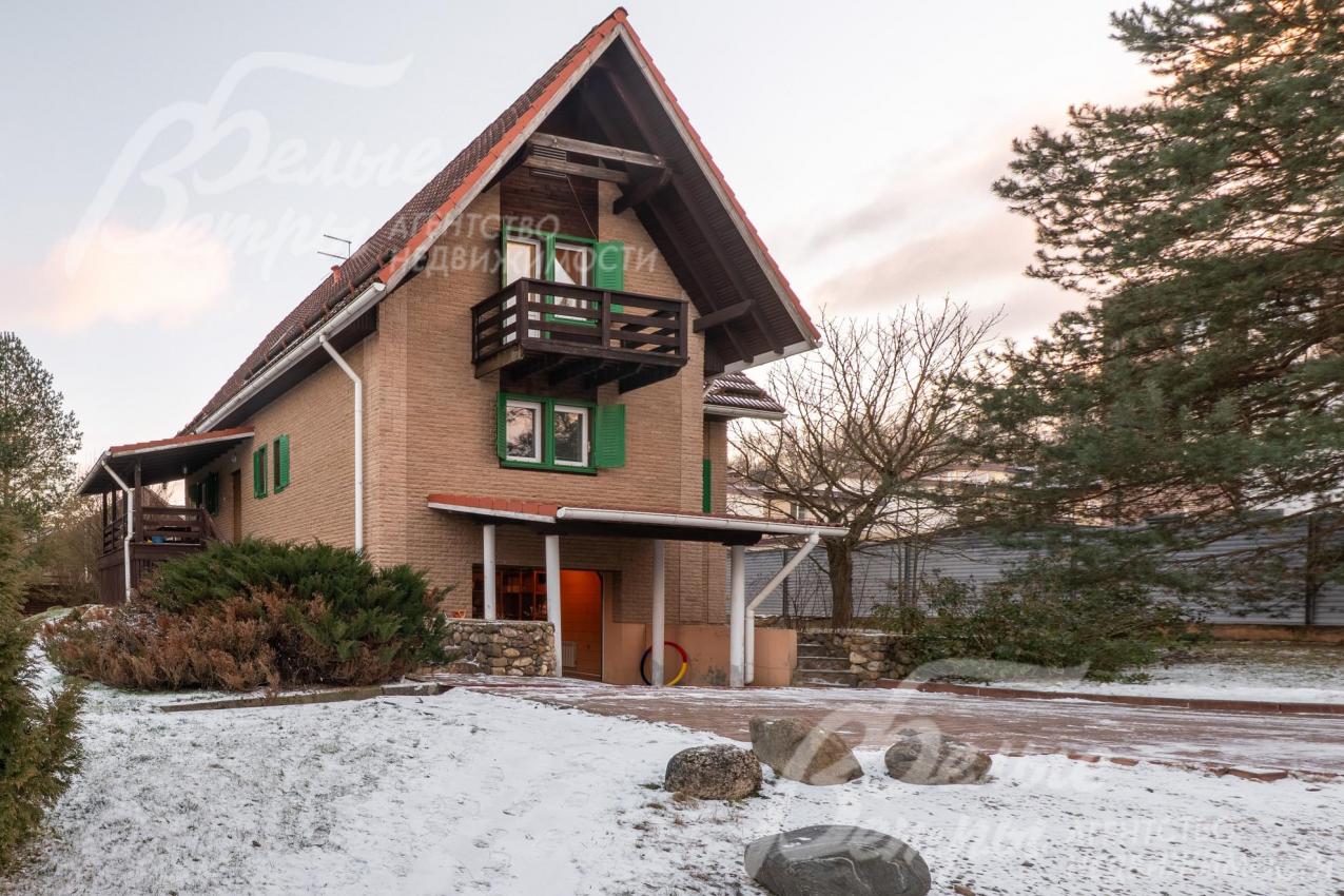 Дом - с крутой двускатной крышей, придающей ему особый шарм, фасад выполнен в тёплых, природных тонах, которые гармонично сочетаются с окружающей зеленью