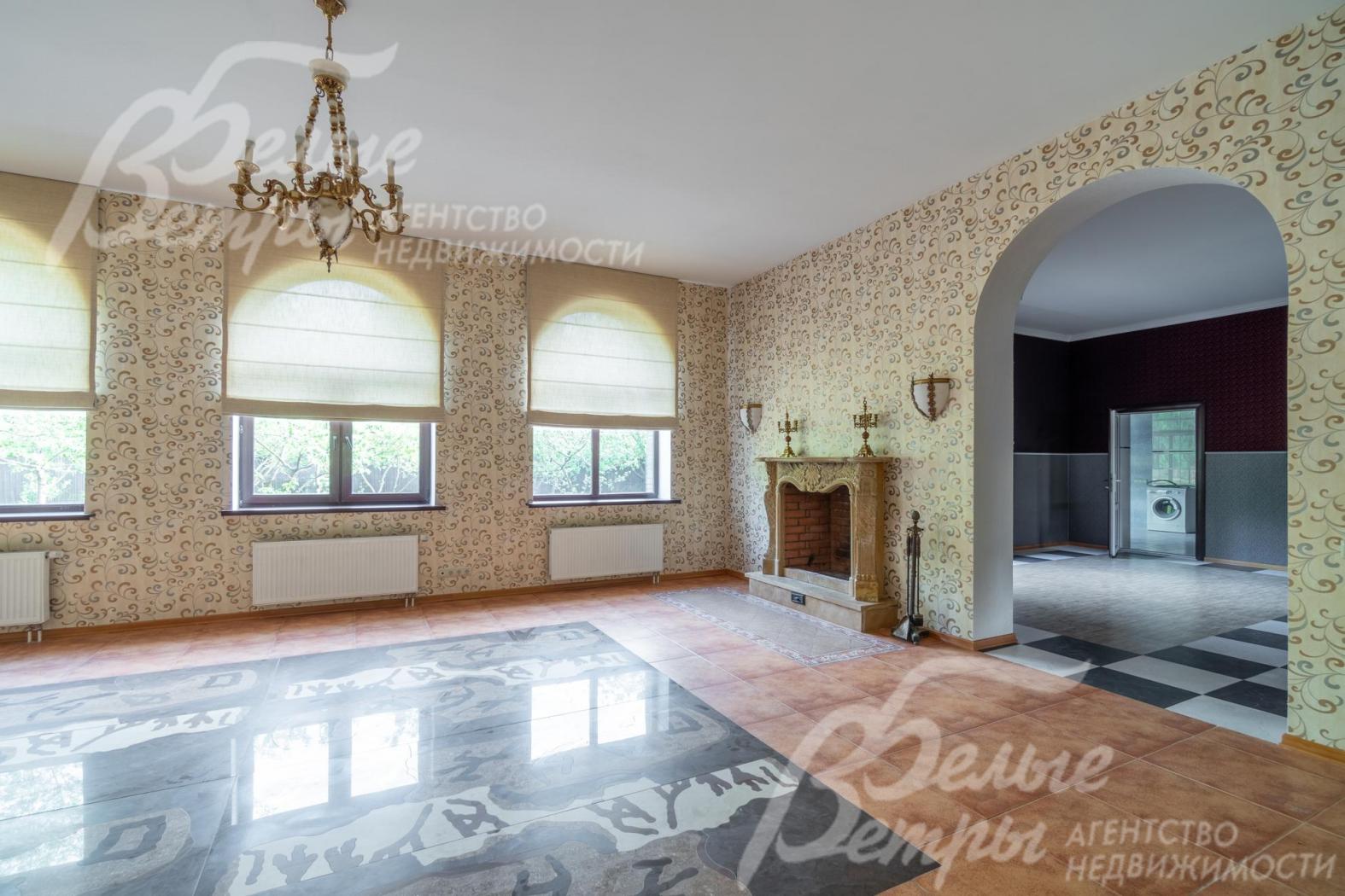 Гостиная с эркерными окнами и классической входной аркой