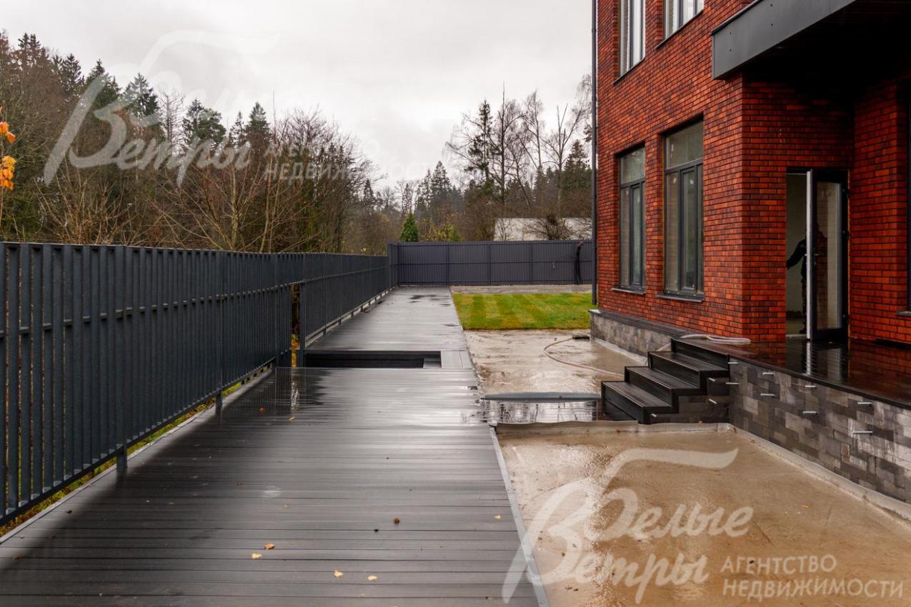 Выход на террасу из кухни, ниже расположена видовая площадка с панорамой на пруд и природу