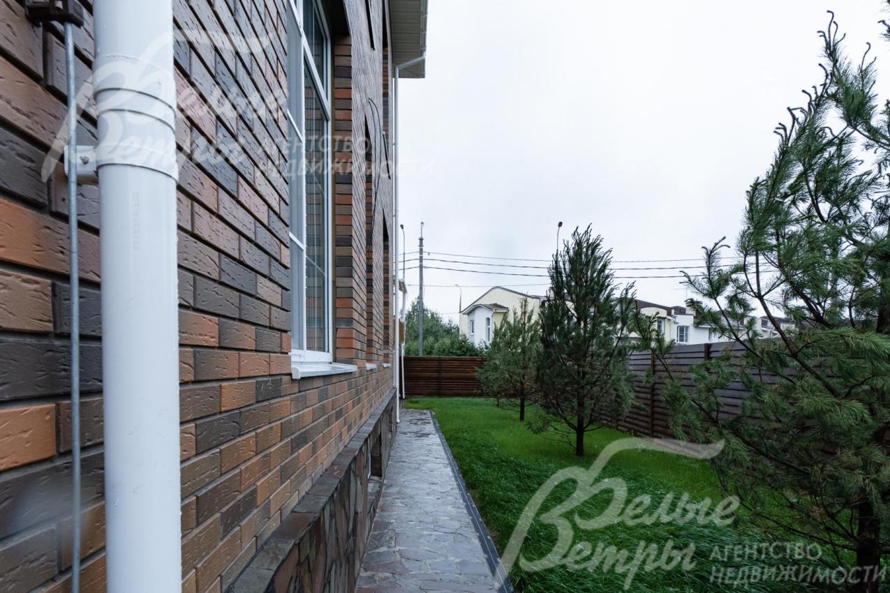 По периметру участка газон и хвойные деревья